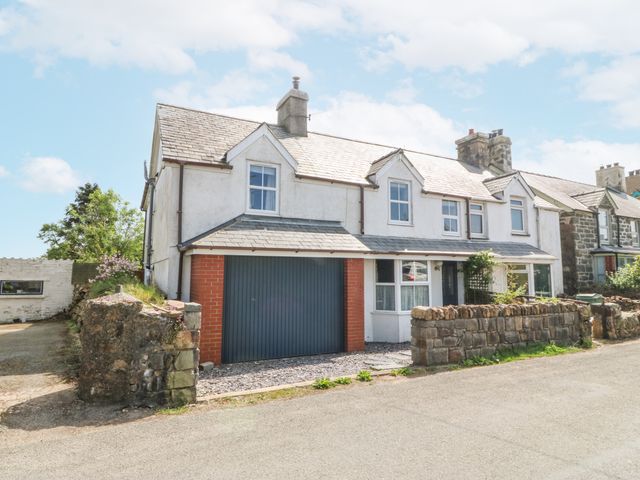A house with a garage and stone wall at Bryn Awel in Mynytho near Abersoch