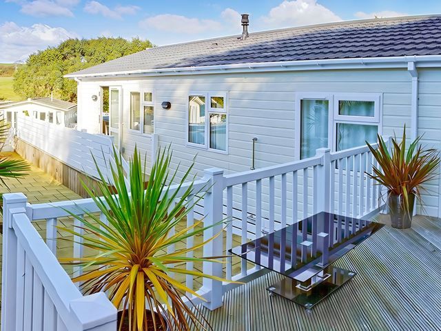 An outdoor deck with a table and plants at The Warren D7 Abersoch