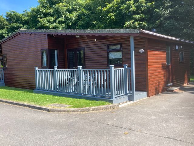 A log cabin with a deck and table with chairs at Lavender Lodge in Saltburn-By-The-Sea
