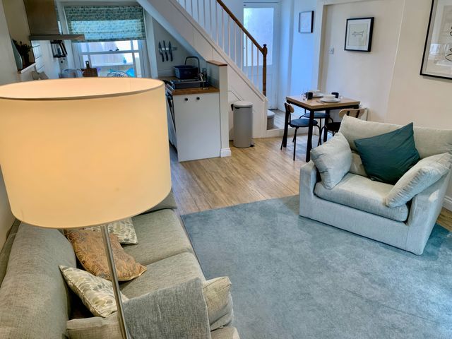 A living room with a sofa and dining table at Bobbin Cottage in Swanage