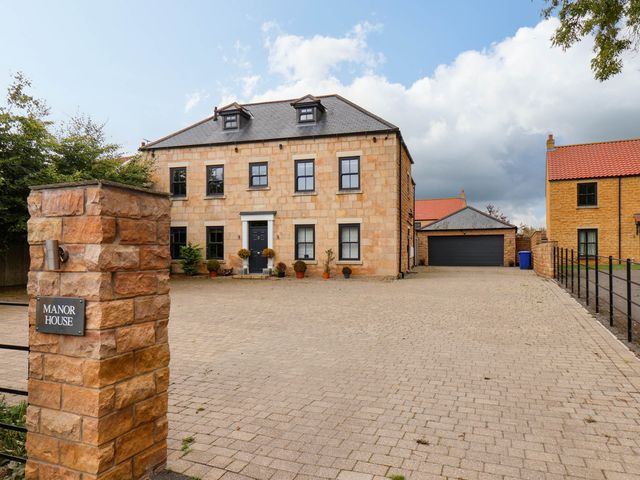 A house with a garage and driveway at Seamer Manor House in Seamer, North Yorkshire
