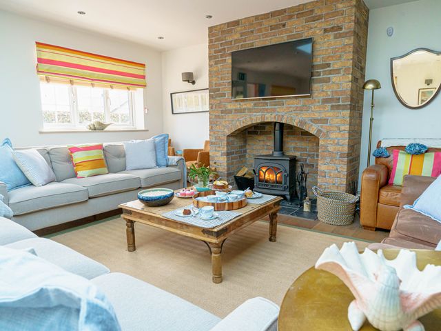 A living room with a fireplace and sofa at Y Graiglwyd Bull Bay near Amlwch