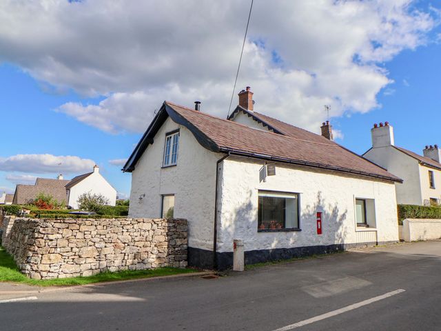 A house with a stone wall on the side at Cwtch in Mold