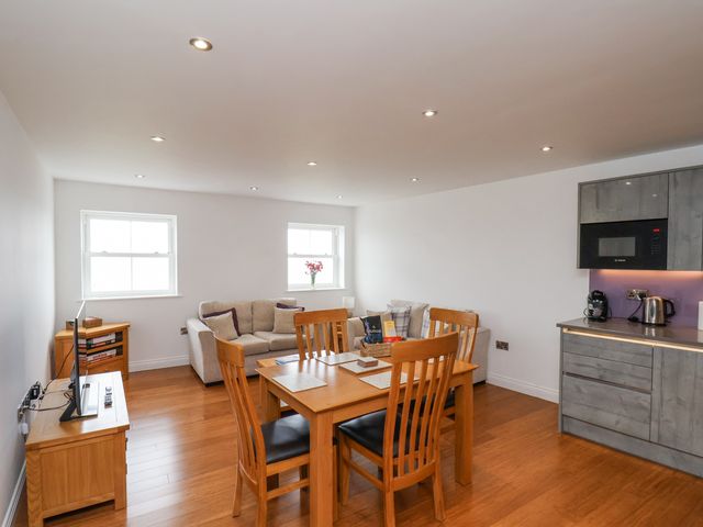 A living room with a dining table and sofa at Sandsend View in Whitby