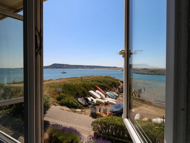 A view of boats and water from a window at Cove Cottage in Weymouth