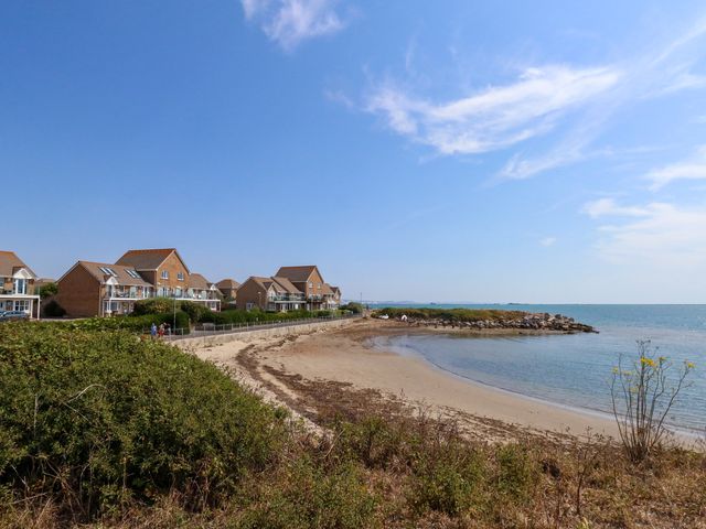 A beach with houses alongside at Cove Cottage in Weymouth