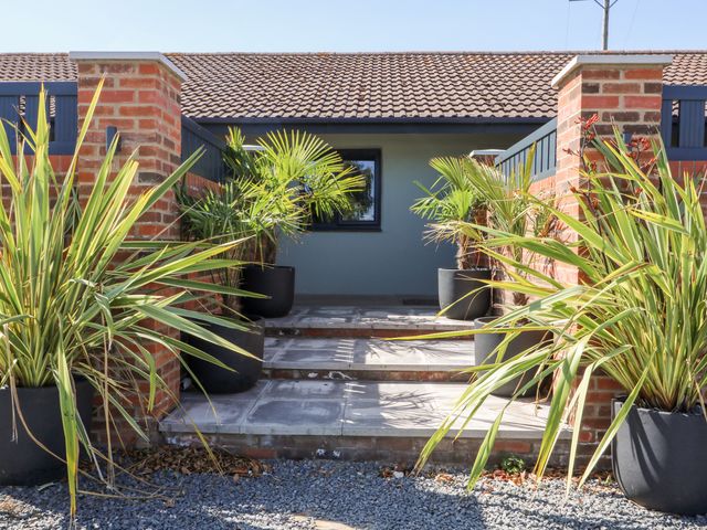 An entrance with steps leading to a house with potted plants along the pathway at Chalet 3 in Sherburn