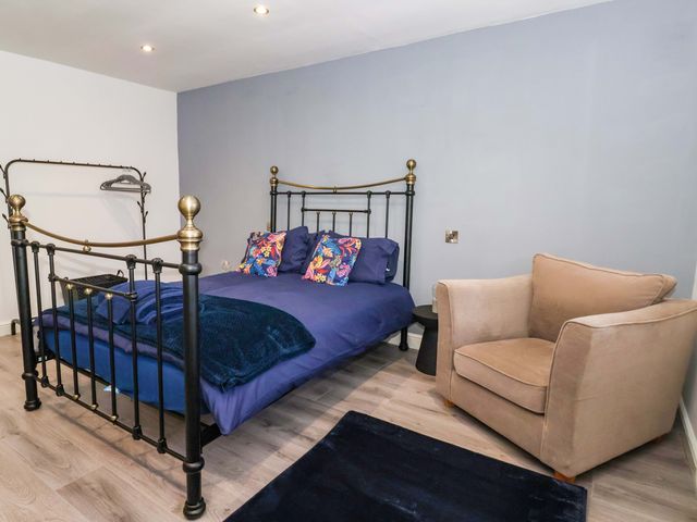 A bedroom with a bed and a chair at Chalet 3 in Sherburn