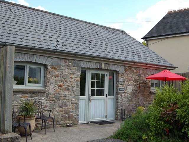 A stone cottage entrance with a table and chairs at Dryslwyn Cottage in Llandeilo