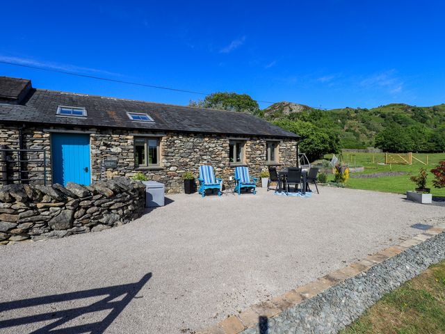 An outdoor area with a stone building and furniture at The Garden Suite at Fiddler Hall Barn Newby Bridge