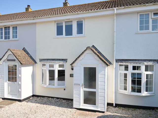 An exterior view of a house with a white door and windows at Shrimper's Cottage Tredrizzick near St Minver