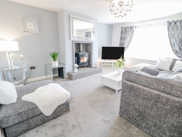 A living room with a fireplace television sofas and a coffee table at SJs Cottage in Castlerock