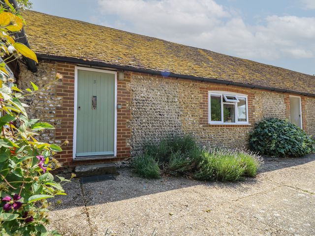 A stone exterior with a green door and window at Byre Cottage 3 Sullington near Storrington
