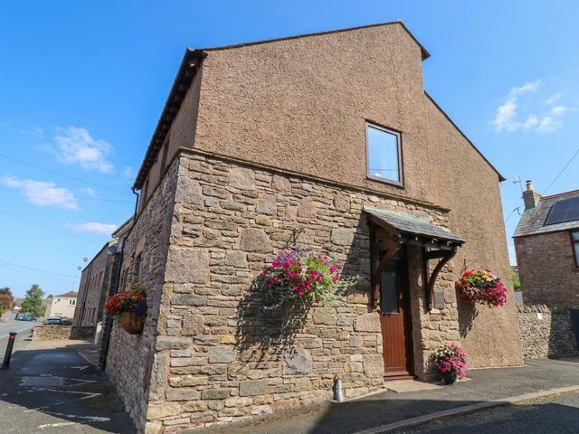 A house with stone walls and flowers at the entrance at Summerseat, Kirkby Stephen
