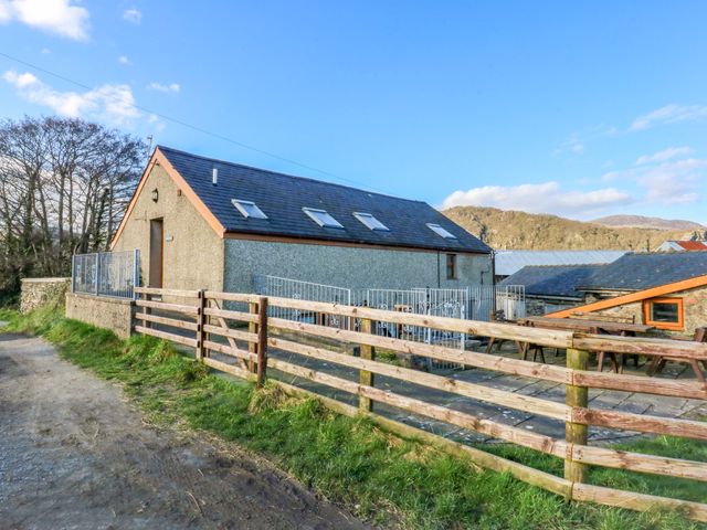 A building with a fence and pathway at Llofft Yr Yd Porthmadog