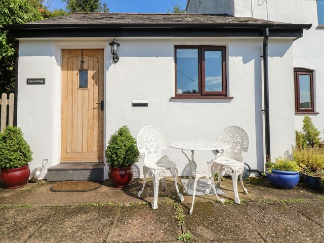 A front entrance with a door and outdoor seating at Alwyn Cottage in Froncysyllte