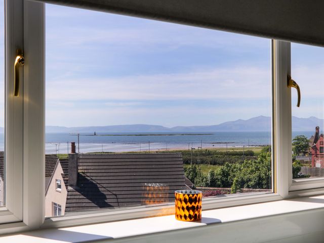 A window view showing rooftops a coastline and mountains in the distance at Seafield Court in Ardrossan