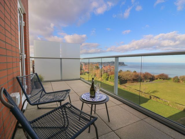 A balcony with chairs and a table overlooking the sea at The Lookout 