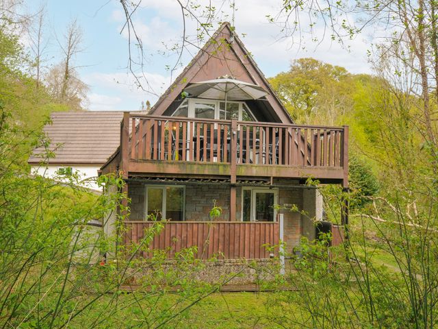 A house with a balcony and trees surrounding it at Hideaway Cottage, St Ann's Chapel, Cornwall