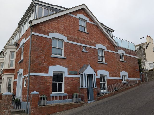 A building with brick walls and multiple windows at Seaside in Lyme Regis