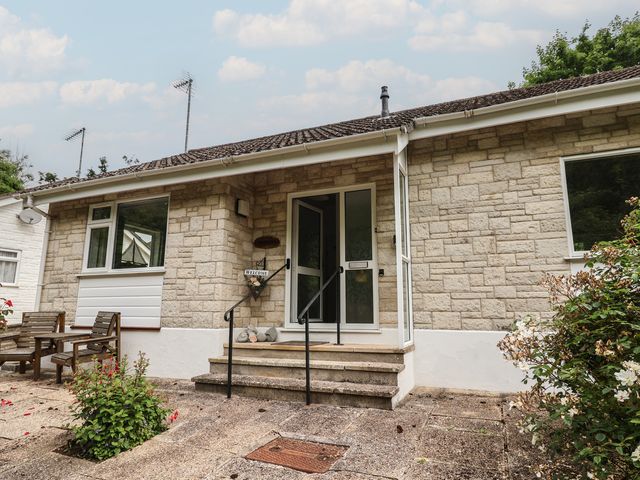 The entrance of a house with stone walls and a front door at High Trees in Lyme Regis