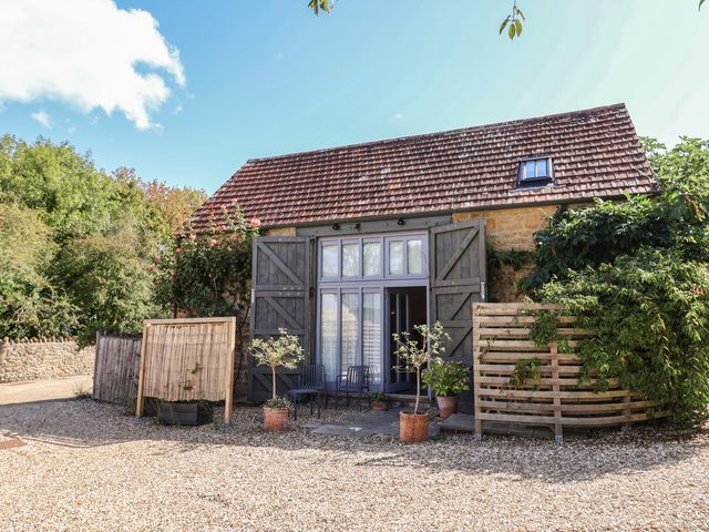 An exterior view of a house with garden features at The Stone Barn in Bridport