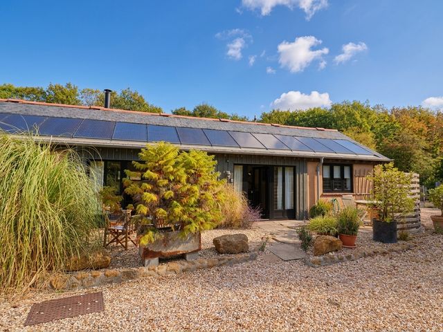 An outdoor view of a house with solar panels and garden at The Dairy in Bridport