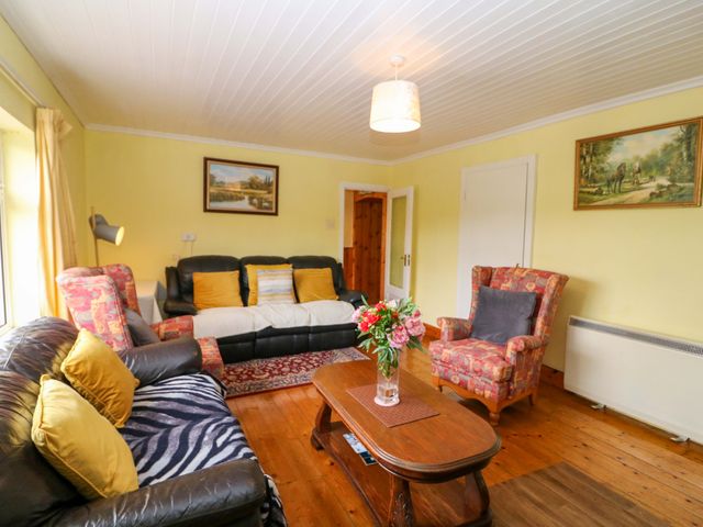 A living room with a sofa, armchair, and coffee table at Forest View in Ballinskelligs, County Kerry