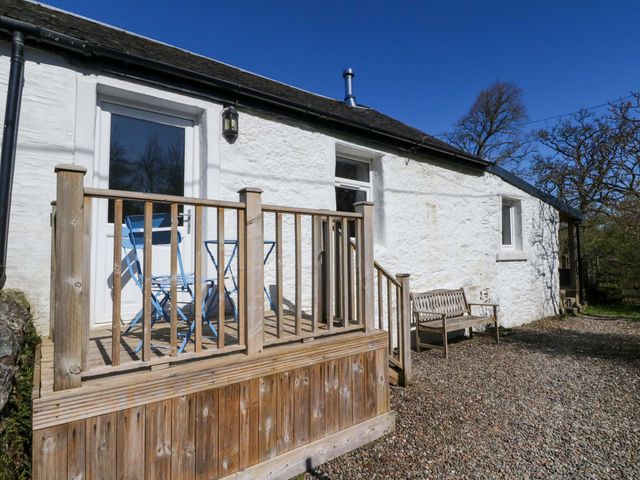 A porch with a table and chairs at Gun Powder Cottage in Tighnabruaich