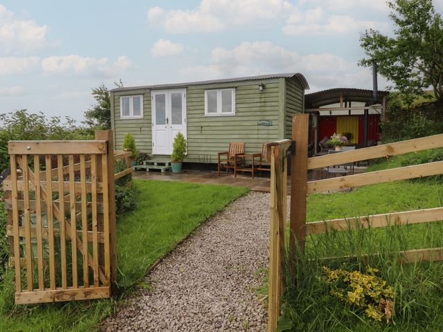 A shepherd's hut with a pathway and gate at The Journeyman Luxury Shepherds Hut in Barnoldswick