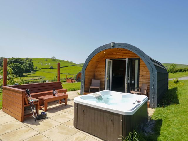 An outdoor area with a hot tub and wooden seating at Beech in Ulverston