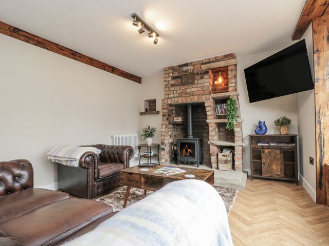 A living room with a fireplace and furniture at Betsy's Burrow