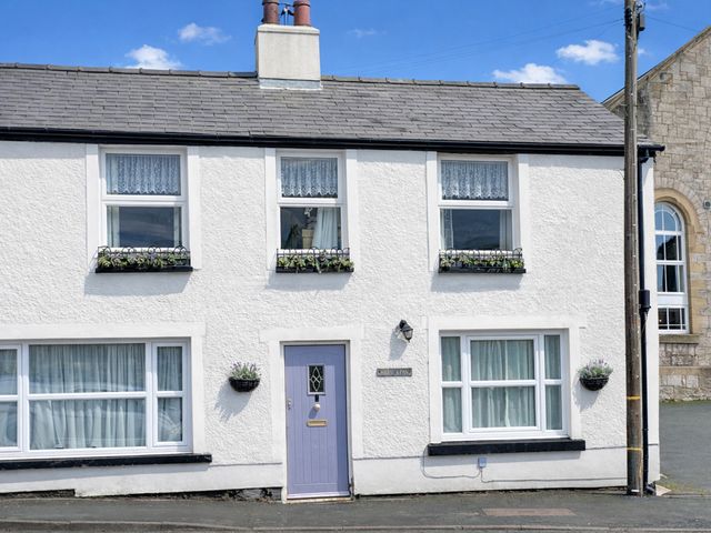A house with a purple door and flower boxes at Waterfall Cottage Dyserth