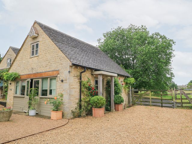 A cottage with a front garden and fence at Pudding Hill Barn Cottage Bibury