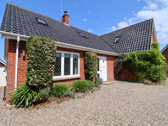 A house with a gravel driveway and garden at Seadrift in Dunwich Near Westleton