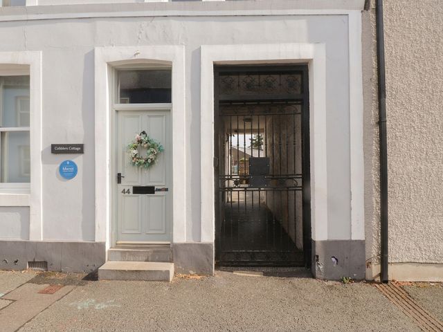 An entrance with a door and gate at Cobblers Cottage in Beaumaris