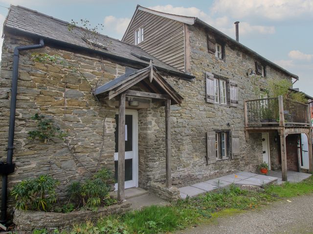 An exterior view of a stone cottage with a balcony at Malt House in Bishop's Castle