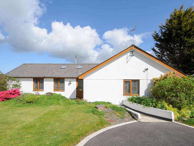 A single-story white house with a pitched roof and garden at Lambley View in Bude