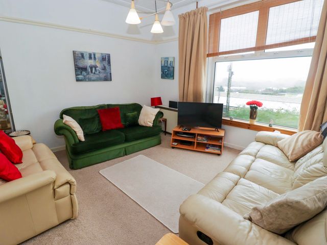 A living room with two sofas and a television at Gwylan Maisonette in Tenby
