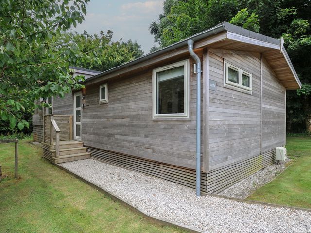 A wooden cabin with a gravel path at 24 Meadow Retreat in Dobwalls