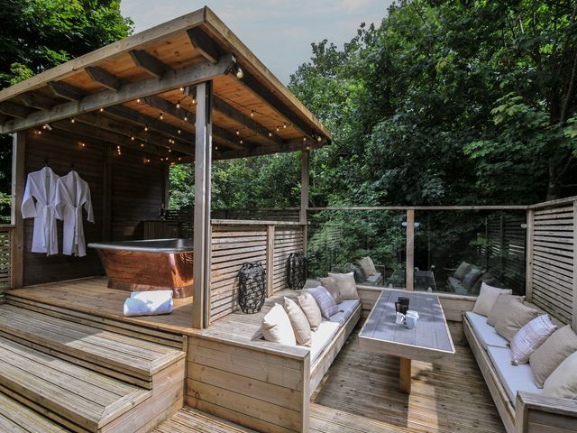 An outdoor spa area with a bath and seating at 24 Meadow Retreat Dobwalls
