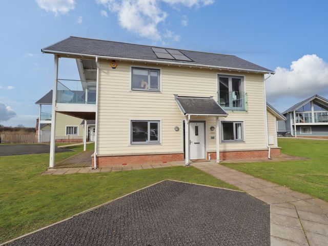 A house with solar panels and a lawn at Spindrifter in Beadnell