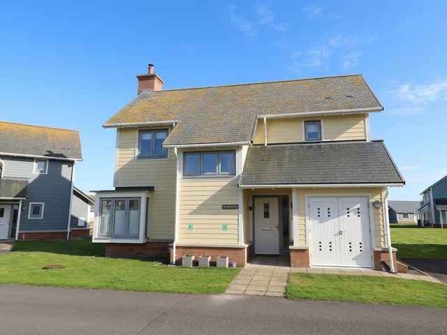 A house with a front door and garage at The Beach Hut in Beadnell