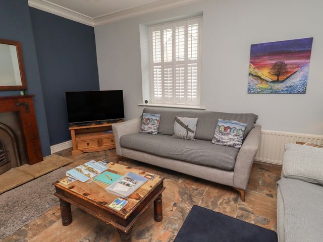 A living room with a television and sofa at Number Seventeen in Amble
