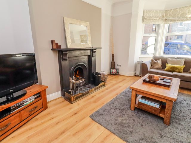 A living room with a fireplace and television at Alnbank in Alnmouth