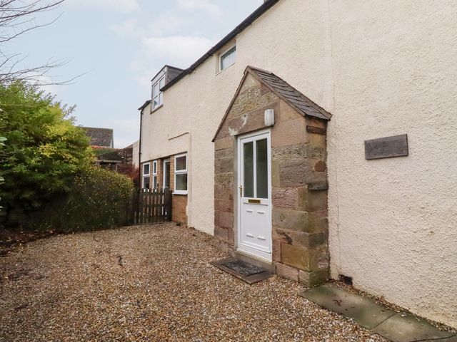 An outdoor entrance area with a door and gravel at Wayside Cottage Newton-by-the-Sea