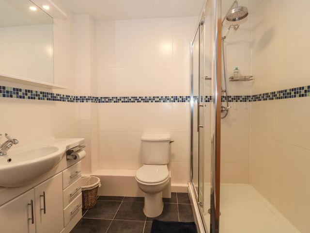 A bathroom with a sink cabinet toilet and glass shower enclosure at Rainbow View in Churchstanton near Churchinford