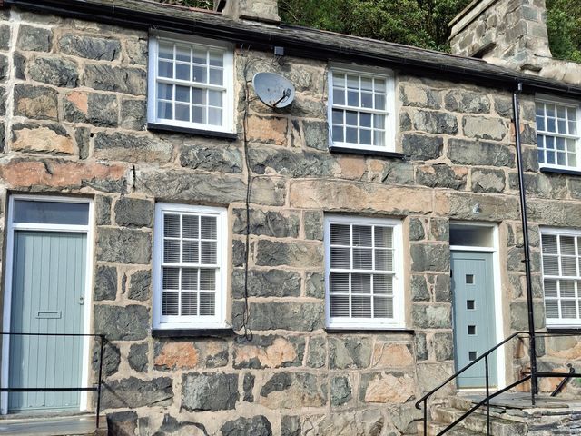 Exterior of a stone house with windows and a door at Ty Driffter in Tremadog