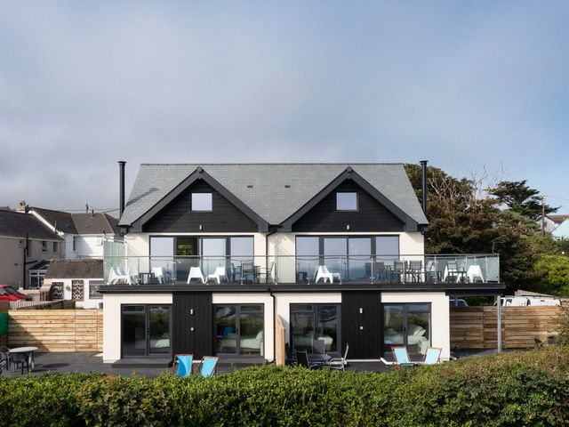 A two-story duplex with balconies and outdoor seating at Treen in St Ives