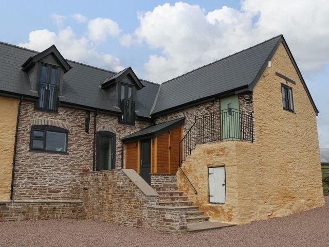 A stone house with slate roof and exterior stairs at Palace Studio in St Weonards
